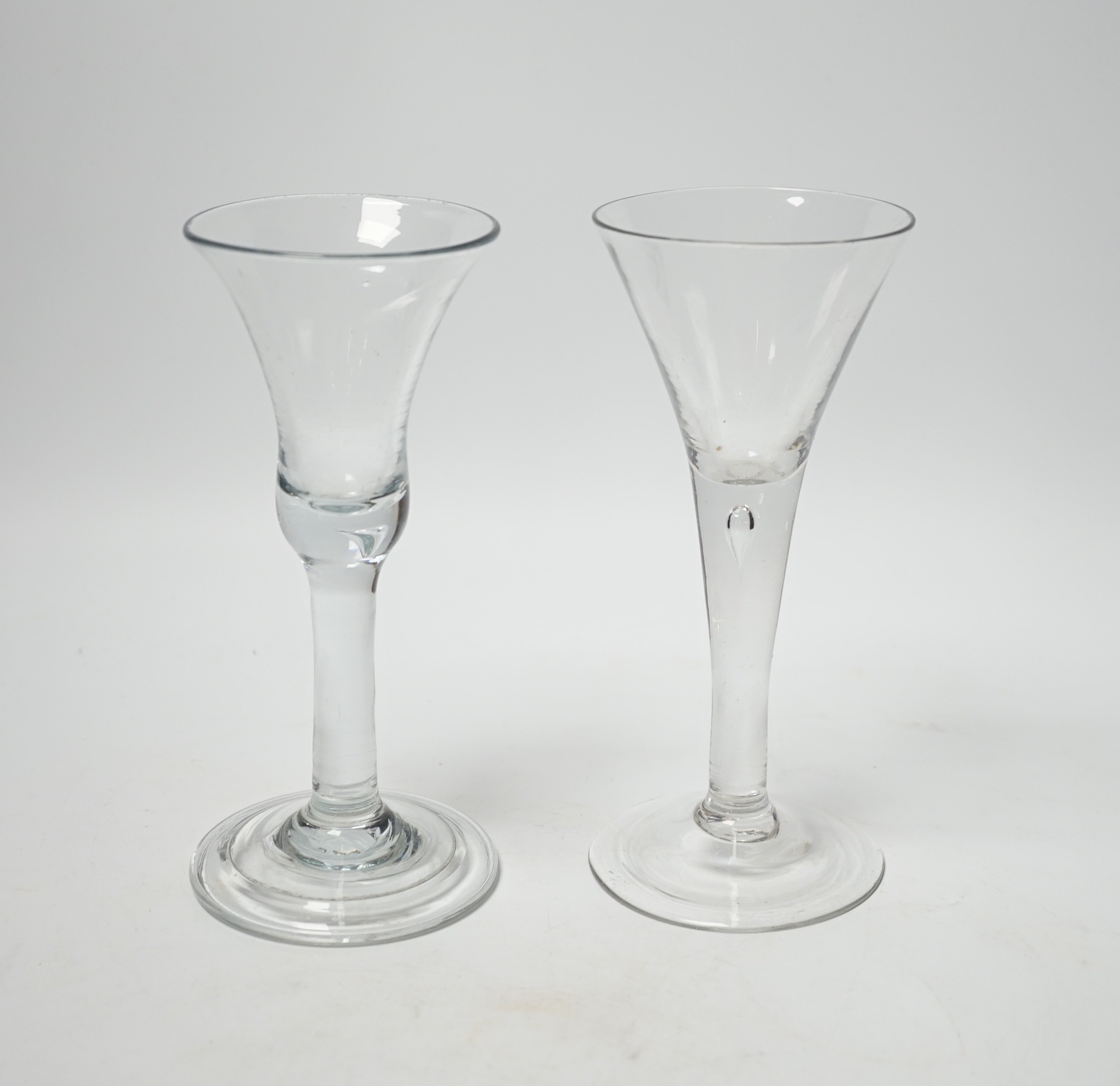 Two Georgian wine glasses, both with plain stems one with tear, the other with bell-shaped bowl and folded foot, the other with trumpet-shaped bowl, both 16.5cm